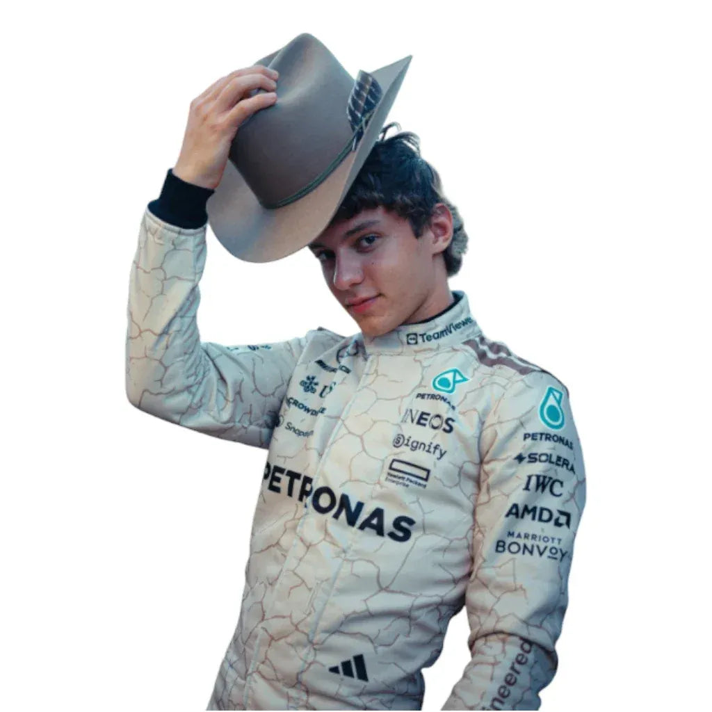 Person wearing a Formula 1 racing suit with Petronas and other sponsor logos, holding a cowboy hat.