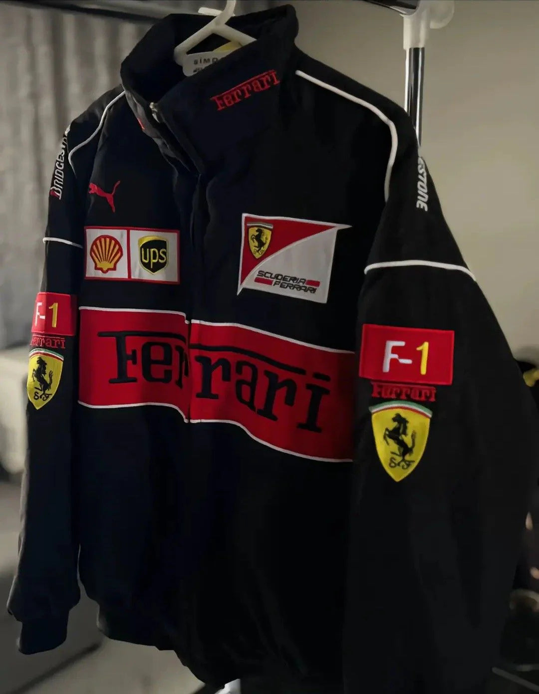 Black jacket with Ferrari and other logos on a hanger