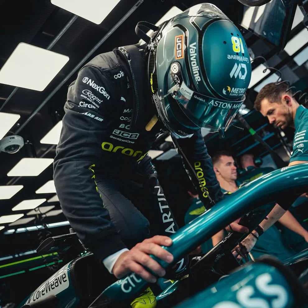 Person in a racing suit and helmet inside a Formula 1 car, with visible branding.