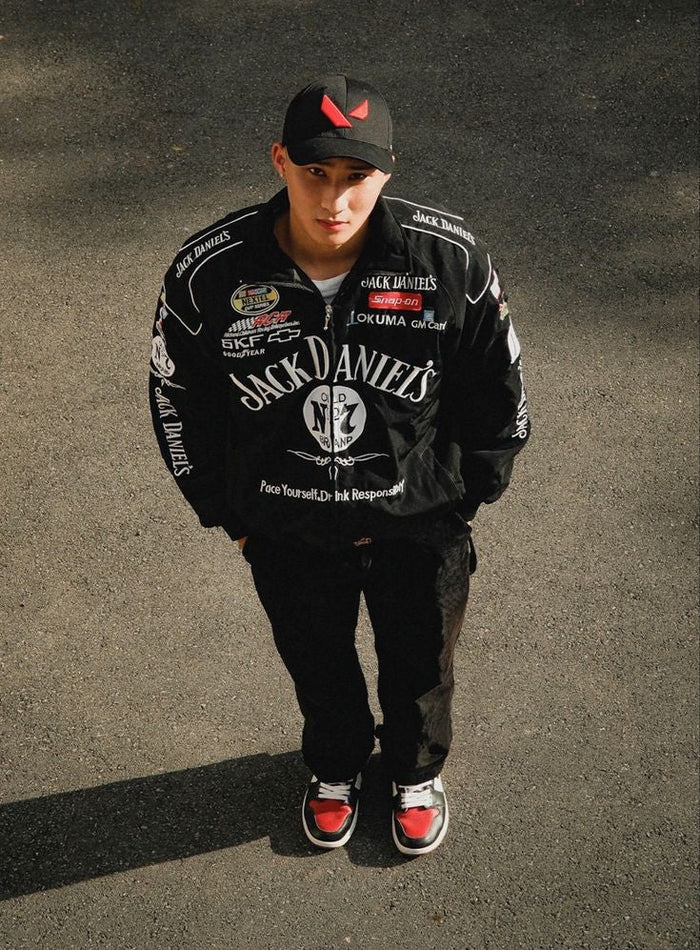 Person wearing a black jacket with Jack Daniel's branding on a dark background