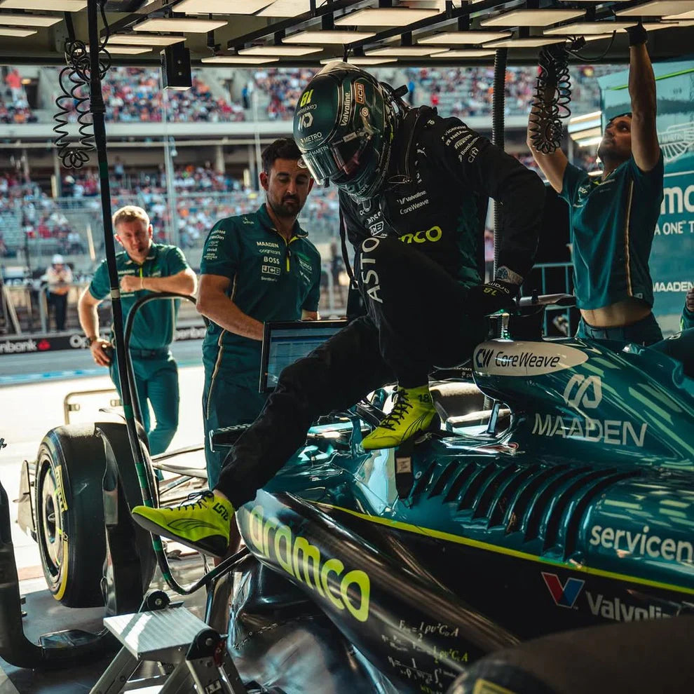 Formula 1 driver getting into a car with team members in the background