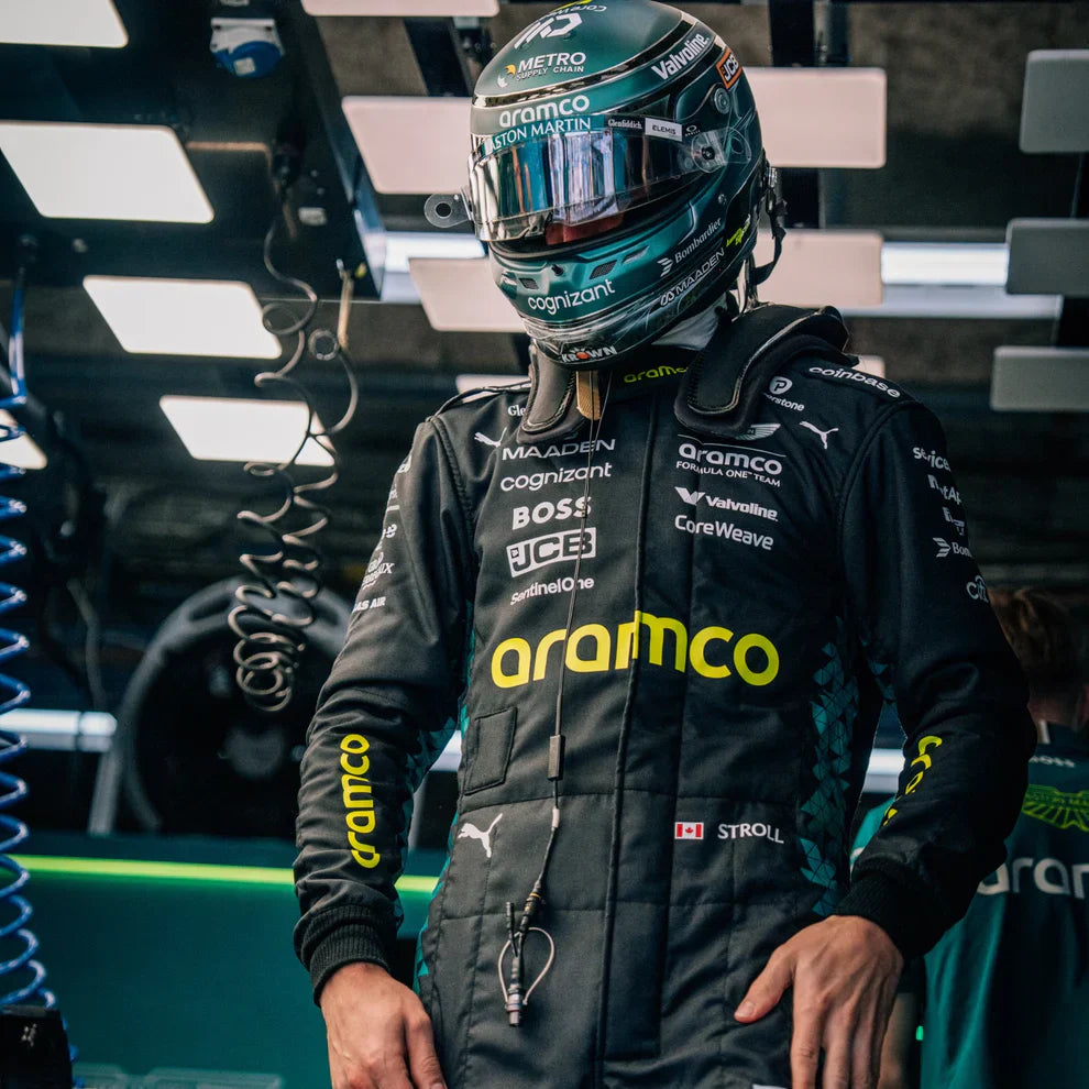 Person wearing a racing suit with Aramco branding in a garage setting