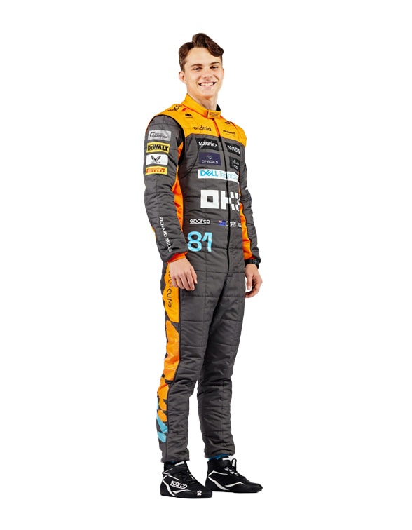 Person wearing a racing suit with various sponsor logos on a white background