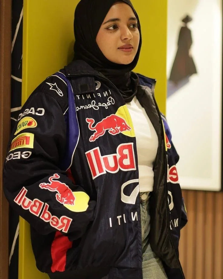 Person wearing a Red Bull branded jacket with a yellow wall in the background