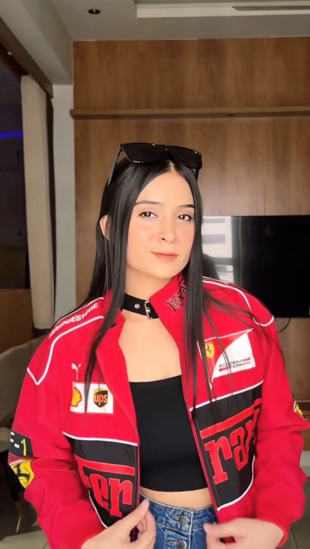 Person wearing a red Ferrari jacket in an indoor setting